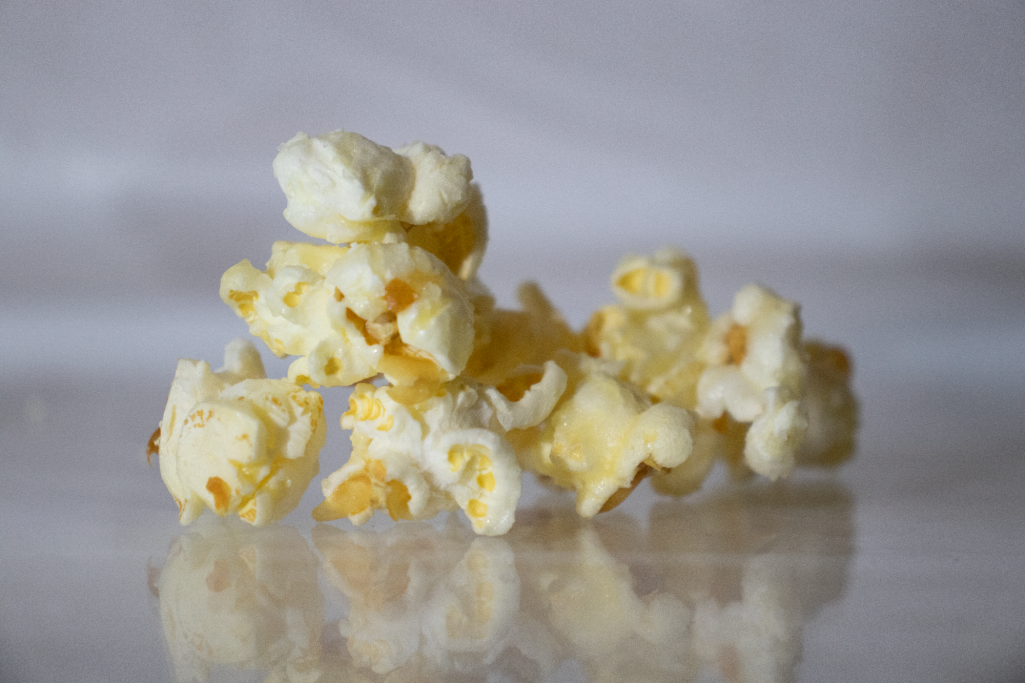Kesselpopcorn Nahaufnahme von karamellisiertem Popcorn auf spiegelndem Untergrund.
