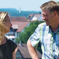 Ehepaar hinter Hilenta Bild von Carole und Jürgen Hieber mit einem Ausschnitt von Öllingen im Hintergrund.